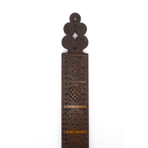 1229 - Treen : A 19thC beech Friesland mangle board with carved flower heads, roundels, etc. later converte... 