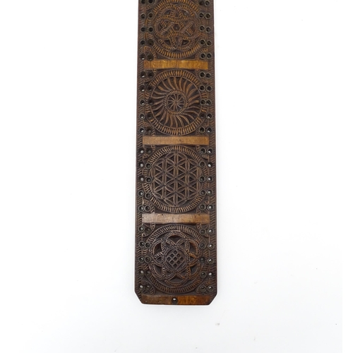 1229 - Treen : A 19thC beech Friesland mangle board with carved flower heads, roundels, etc. later converte... 