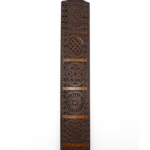 1229 - Treen : A 19thC beech Friesland mangle board with carved flower heads, roundels, etc. later converte... 