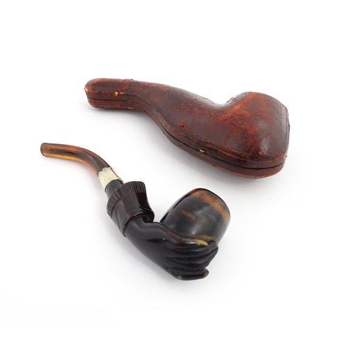 1253 - A Victorian meerschaum pipe carved as a hand with cuff holding the bowl, with amber mouthpiece and s... 