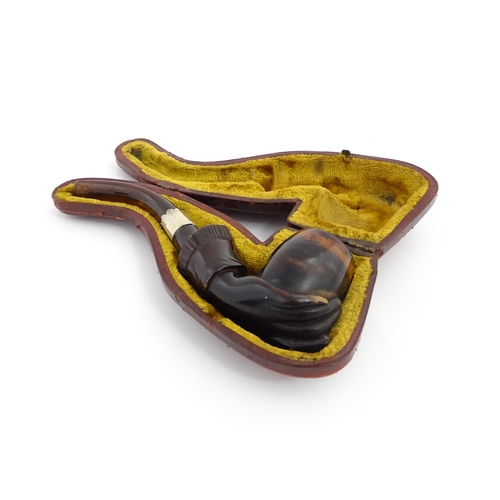 1253 - A Victorian meerschaum pipe carved as a hand with cuff holding the bowl, with amber mouthpiece and s... 