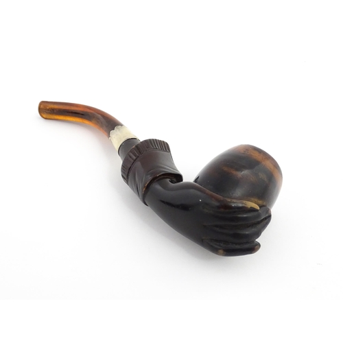 1253 - A Victorian meerschaum pipe carved as a hand with cuff holding the bowl, with amber mouthpiece and s... 