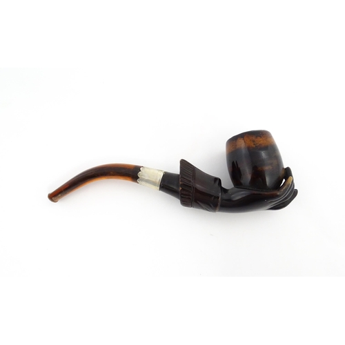 1253 - A Victorian meerschaum pipe carved as a hand with cuff holding the bowl, with amber mouthpiece and s... 