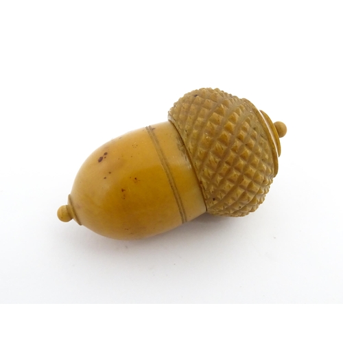 1257 - A Victorian carved coquilla nut thimble case modelled as an acorn. Containing a Victorian silver thi... 