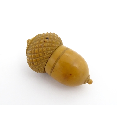 1257 - A Victorian carved coquilla nut thimble case modelled as an acorn. Containing a Victorian silver thi... 