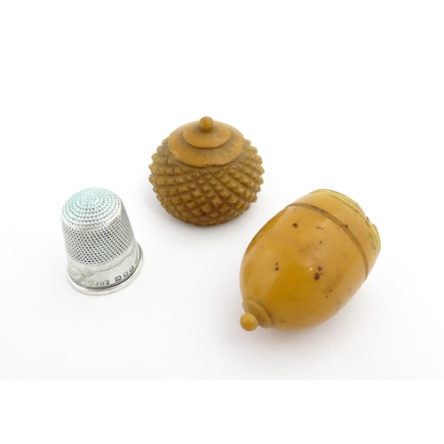 1257 - A Victorian carved coquilla nut thimble case modelled as an acorn. Containing a Victorian silver thi... 