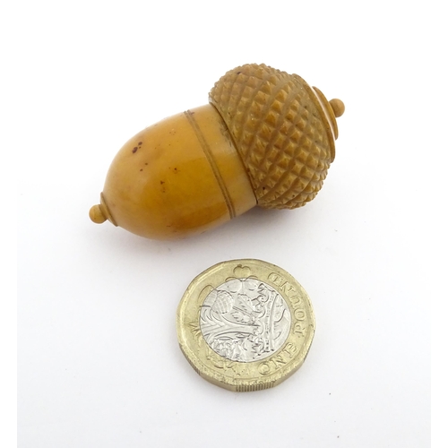 1257 - A Victorian carved coquilla nut thimble case modelled as an acorn. Containing a Victorian silver thi... 