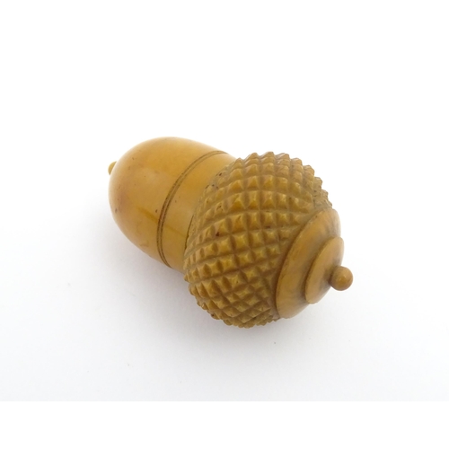 1257 - A Victorian carved coquilla nut thimble case modelled as an acorn. Containing a Victorian silver thi... 