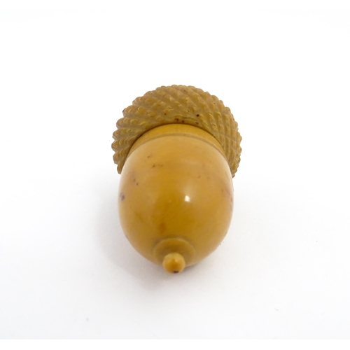 1257 - A Victorian carved coquilla nut thimble case modelled as an acorn. Containing a Victorian silver thi... 