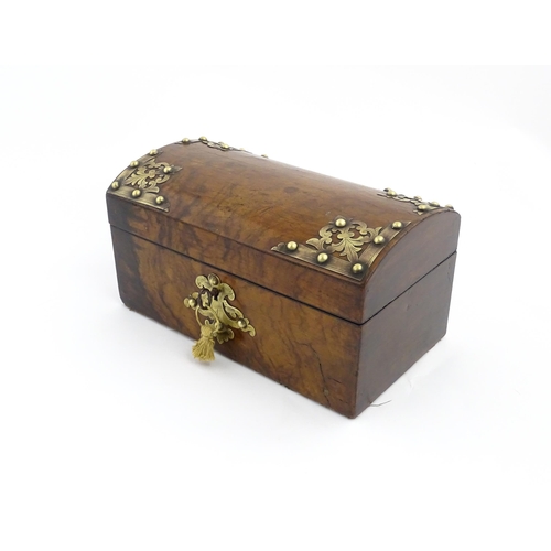 1269 - A 19thC walnut box, the dome top with applied brass mounts, opening to reveal a fitted interior and ... 