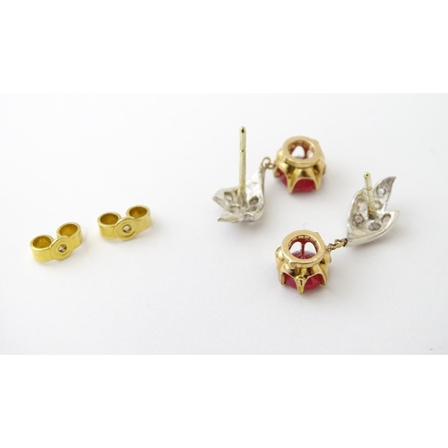 685 - A pair of drop earrings set with diamonds  and a ruby drop. Approx 3/4