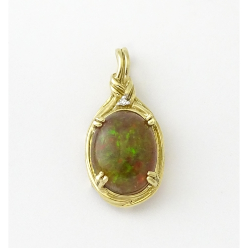 686 - A 9ct gold pendant set with opal cabochon  surmounted by a diamond. Approx 1