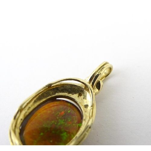 686 - A 9ct gold pendant set with opal cabochon  surmounted by a diamond. Approx 1