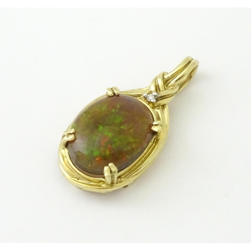 686 - A 9ct gold pendant set with opal cabochon  surmounted by a diamond. Approx 1