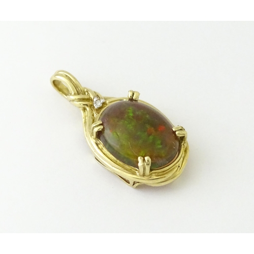 686 - A 9ct gold pendant set with opal cabochon  surmounted by a diamond. Approx 1