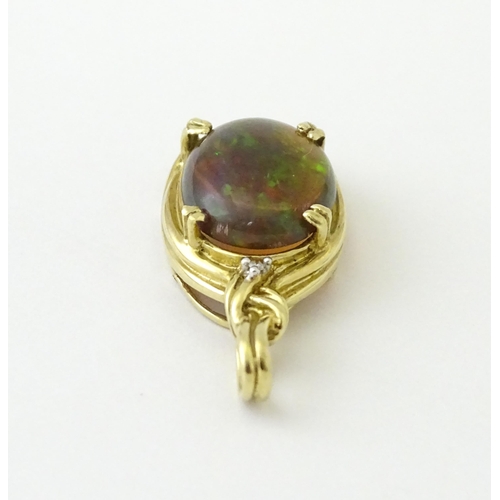 686 - A 9ct gold pendant set with opal cabochon  surmounted by a diamond. Approx 1