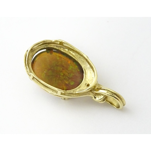 686 - A 9ct gold pendant set with opal cabochon  surmounted by a diamond. Approx 1