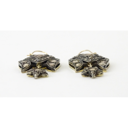 704 - A pair of yellower metal drop earrings set with a profusion of diamonds. Approx. 1 1/2