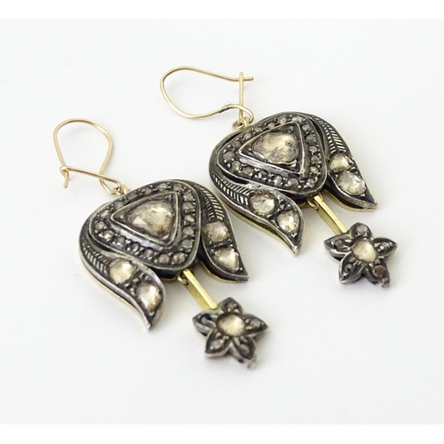 704 - A pair of yellower metal drop earrings set with a profusion of diamonds. Approx. 1 1/2