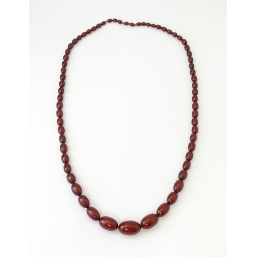 707 - A vintage necklace of graduated cherry amber coloured beads. Approx. 32