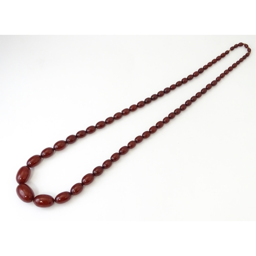 707 - A vintage necklace of graduated cherry amber coloured beads. Approx. 32