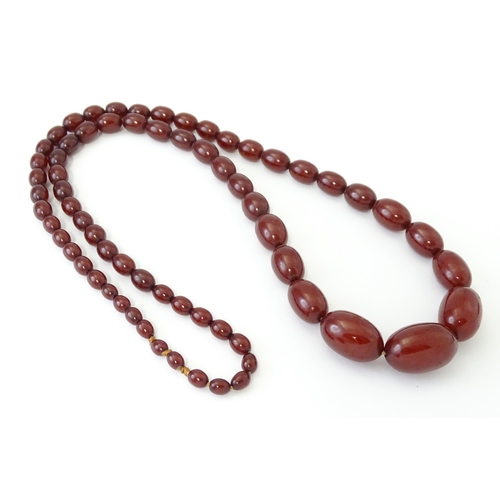 707 - A vintage necklace of graduated cherry amber coloured beads. Approx. 32