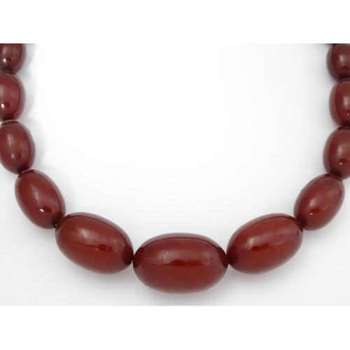 707 - A vintage necklace of graduated cherry amber coloured beads. Approx. 32