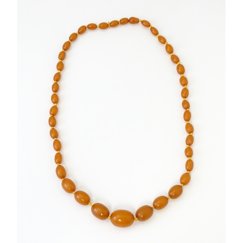 708 - A vintage necklace of graduated amber coloured beads. Approx. 24