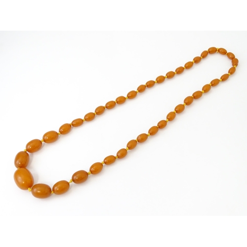 708 - A vintage necklace of graduated amber coloured beads. Approx. 24