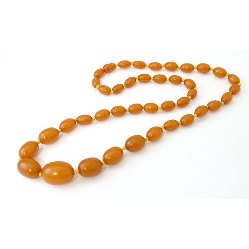 708 - A vintage necklace of graduated amber coloured beads. Approx. 24