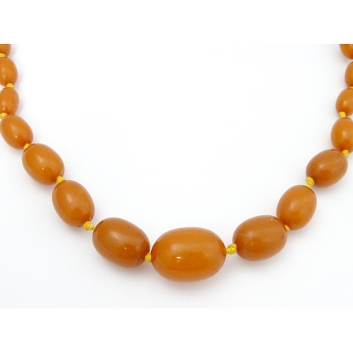 708 - A vintage necklace of graduated amber coloured beads. Approx. 24