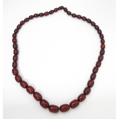 709 - A vintage necklace of graduated cherry amber coloured beads. Approx. 30