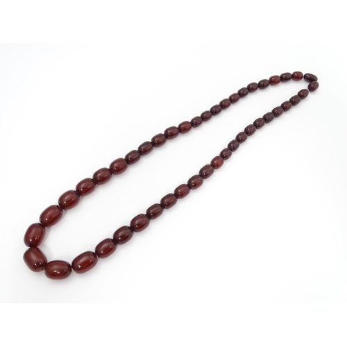 709 - A vintage necklace of graduated cherry amber coloured beads. Approx. 30