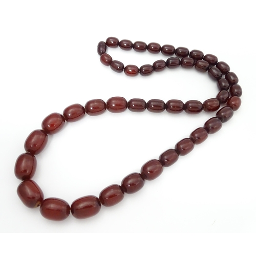 709 - A vintage necklace of graduated cherry amber coloured beads. Approx. 30