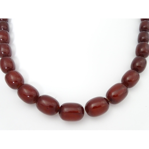 709 - A vintage necklace of graduated cherry amber coloured beads. Approx. 30