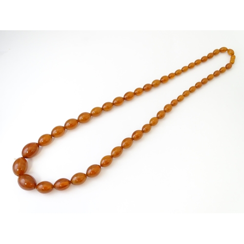 710 - A vintage necklace of graduated amber coloured beads. Approx. 3