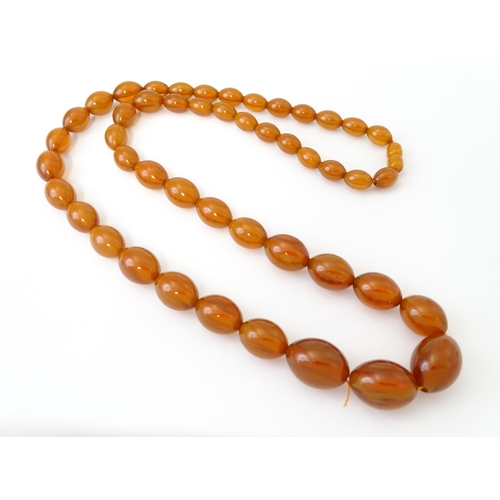 710 - A vintage necklace of graduated amber coloured beads. Approx. 3