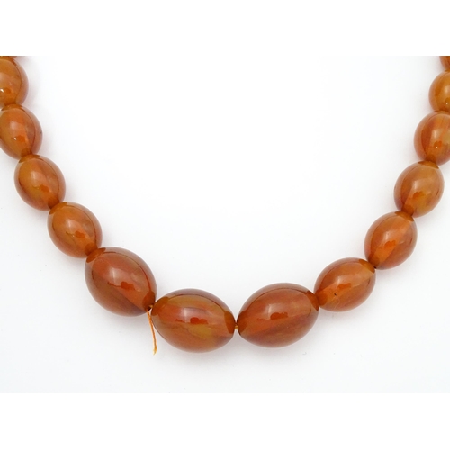 710 - A vintage necklace of graduated amber coloured beads. Approx. 3