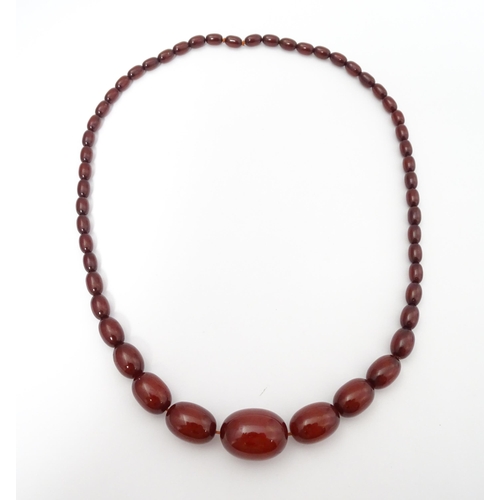 711 - A vintage necklace of graduated cherry amber coloured beads. Approx. 28