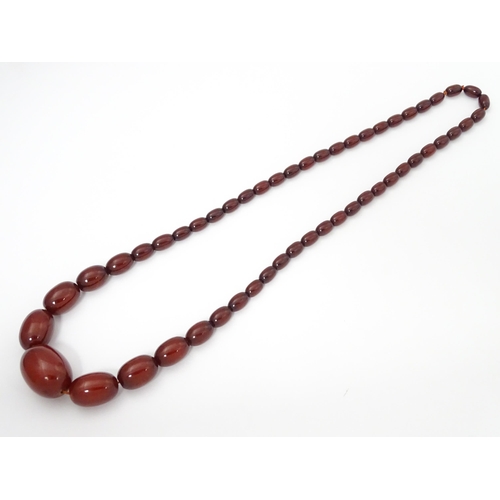 711 - A vintage necklace of graduated cherry amber coloured beads. Approx. 28