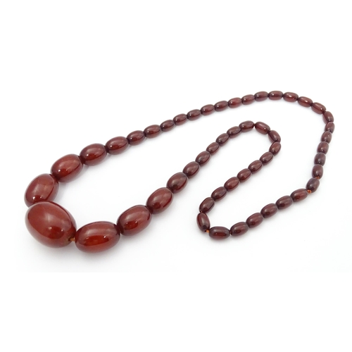 711 - A vintage necklace of graduated cherry amber coloured beads. Approx. 28