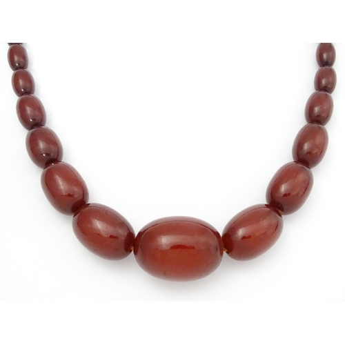 711 - A vintage necklace of graduated cherry amber coloured beads. Approx. 28