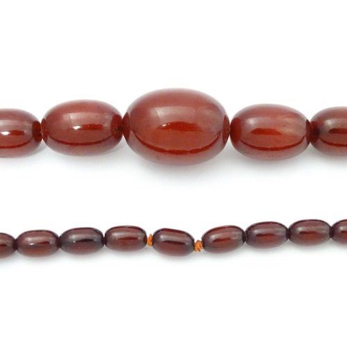 711 - A vintage necklace of graduated cherry amber coloured beads. Approx. 28