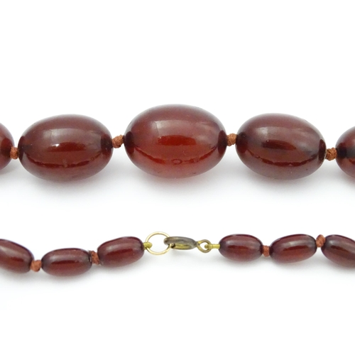 712 - A vintage necklace of graduated cherry amber coloured beads. Approx. 36