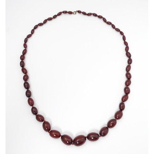 712 - A vintage necklace of graduated cherry amber coloured beads. Approx. 36