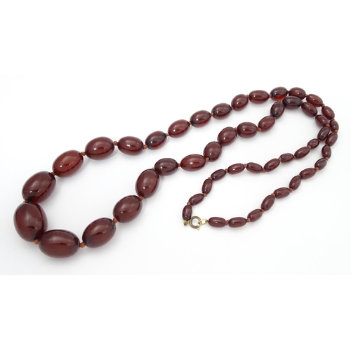 712 - A vintage necklace of graduated cherry amber coloured beads. Approx. 36