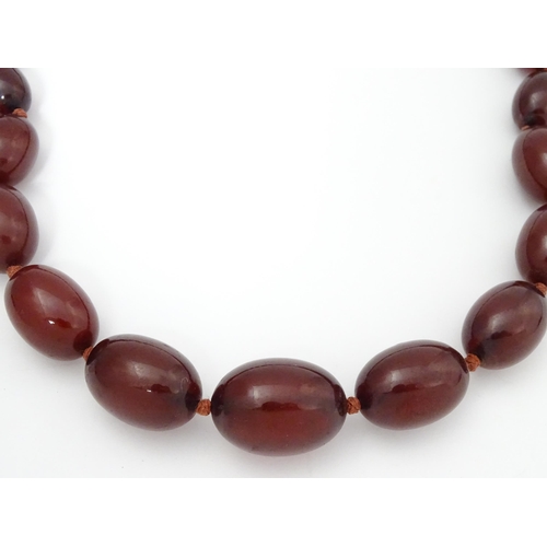 712 - A vintage necklace of graduated cherry amber coloured beads. Approx. 36