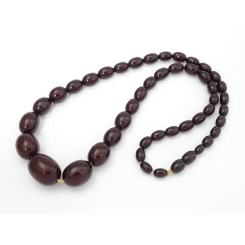 713 - A vintage necklace of graduated cherry amber coloured beads. Approx. 20