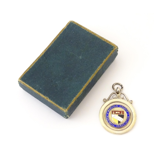 737 - Football Interest : A cased silver medal / fob with enamel decoration for Norfolk County Football As... 