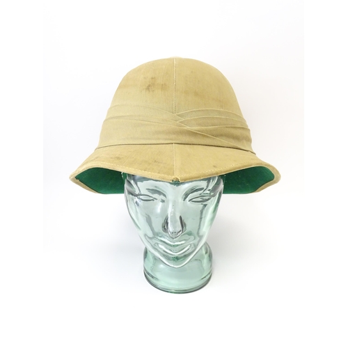 800 - Militaria : an early 20thC pith helmet by Linney, London, with khaki drill cotton exterior, the inte... 